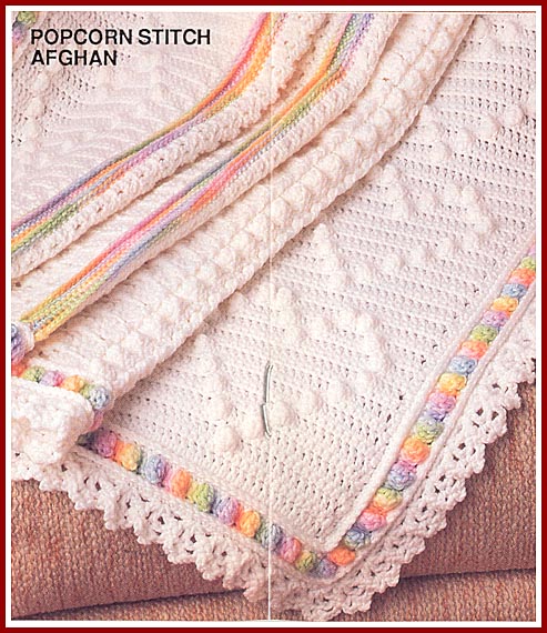 Auntie Pats Afghan is crocheted in worsted weight yarn and features popcorn heart panels alternating with a lacy open shell.