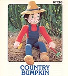 Country Bumpkin boy soft sculpture doll wearing overalls and straw hat.